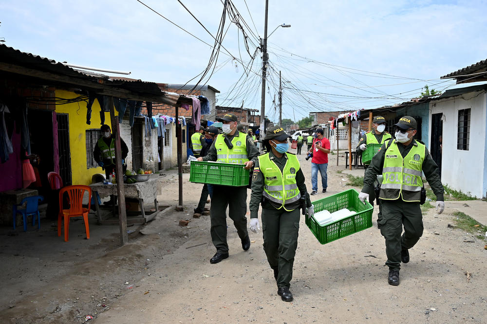 Police officers deliver lunch boxes in Cali, Colombia — a response to reports of hunger during the pandemic.