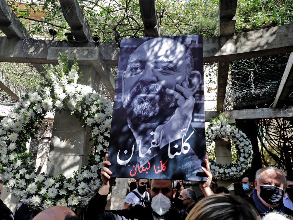 Friends and family members of slain prominent Lebanese activist and intellectual Lokman Slim (shown in the raised image), attend a memorial ceremony in the garden of the family residence in the capital Beirut's southern suburbs, a week after he was found dead in his car, on Feb. 11. Slim, 58, was an outspoken critic of Hezbollah.