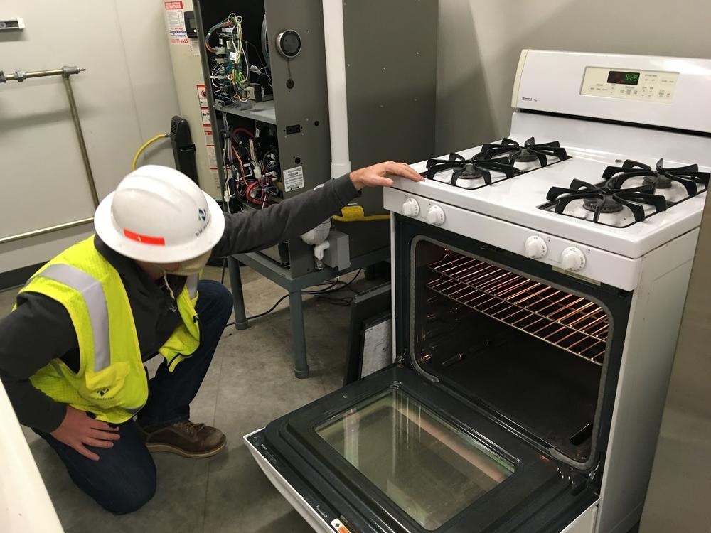 Darren Arnold of NW Natural tests a natural gas stove to see how well it works when it's burning a lower carbon gas mixture.