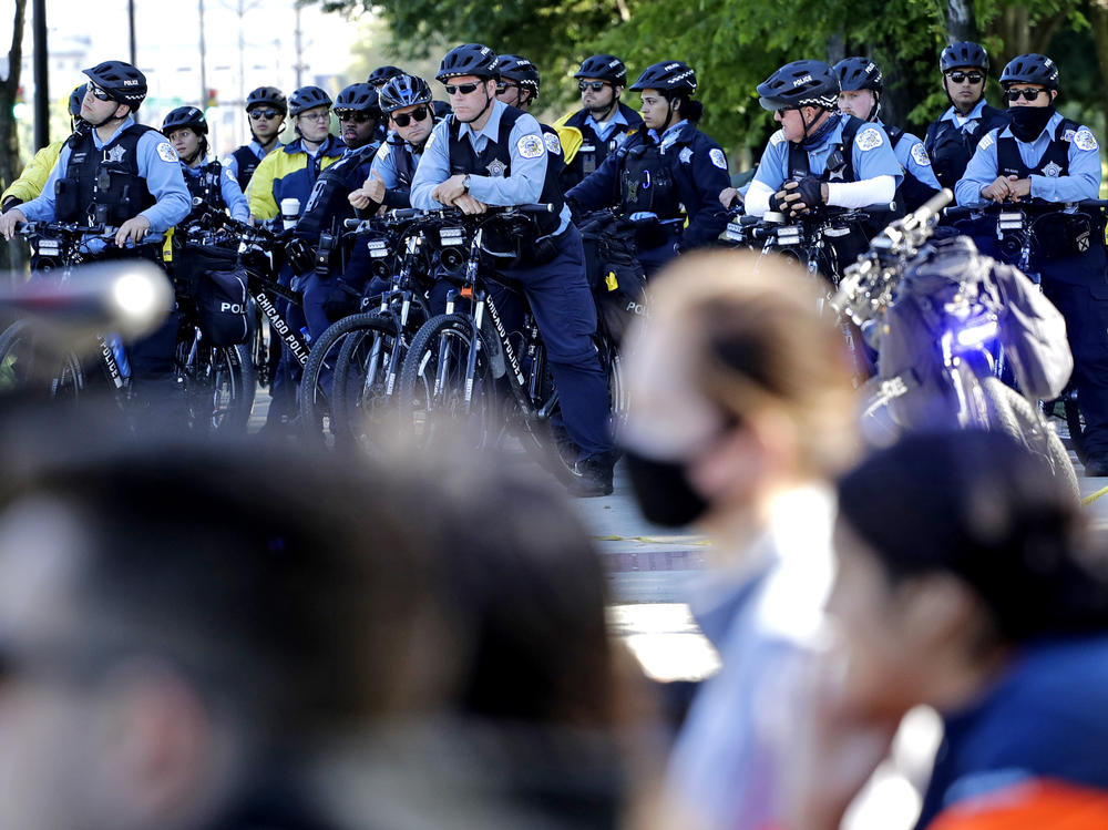 Chicago Police officers watch demonstrators on Lake Shore Drive during a protest in honor of George Floyd, in June, in  downtown Chicago. A new report says police were unprepared and ill-equipped to handle the summer's protests.