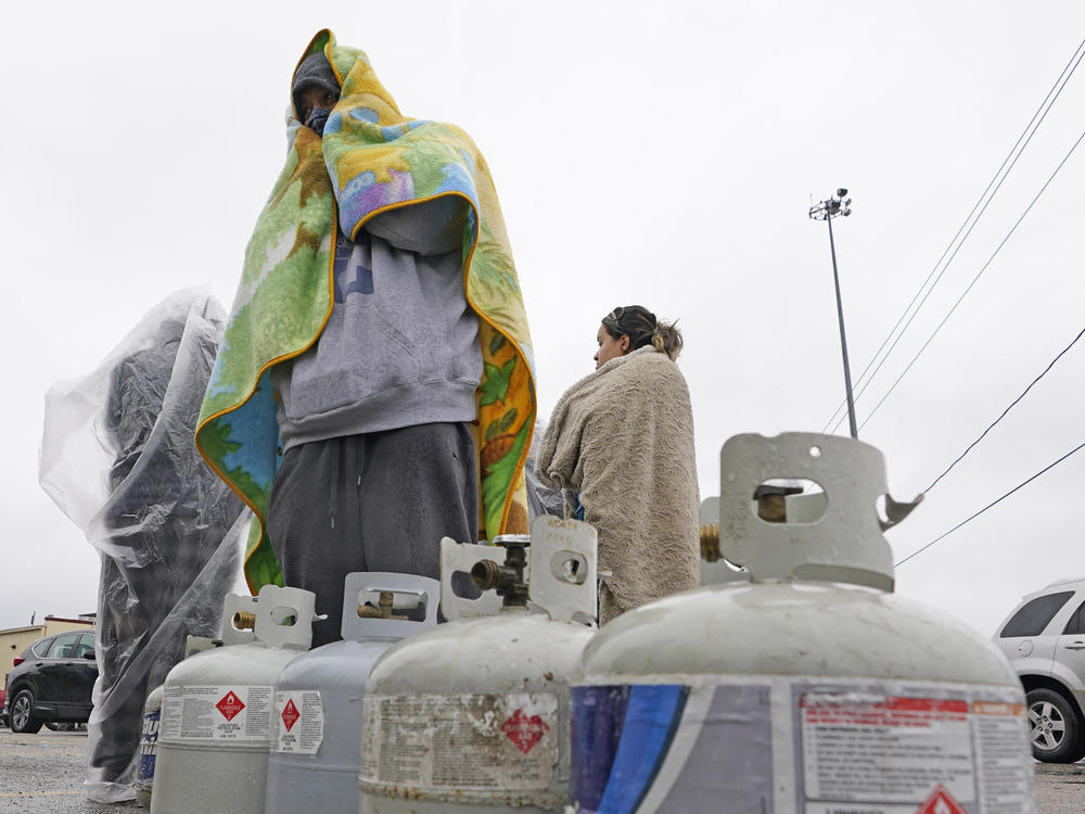 Carlos Mandez waits in line to fill his propane tanks on Wednesday in Houston. Customers had to wait over an hour in the freezing rain to fill their tanks after historic snowfall and widespread power outages in Texas.