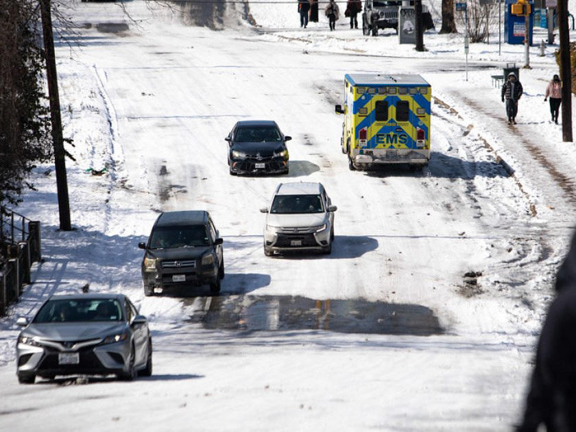 An ambulance drives on Oltorf Street in the Travis Heights neighborhood of South Austin on Tuesday.