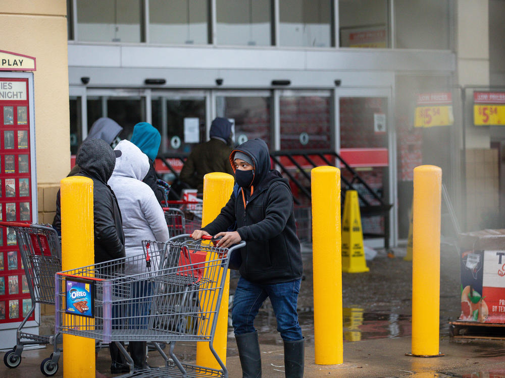 People wait in long lines at an H-E-B grocery store in Austin, Texas, on Wednesday. The large supermarket chain said the 
