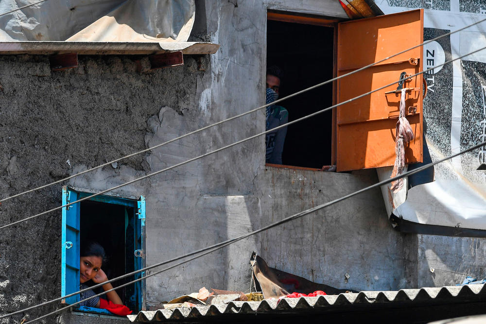 Residents look out of their windows at the Dharavi slum during a government-imposed nationwide lockdown.