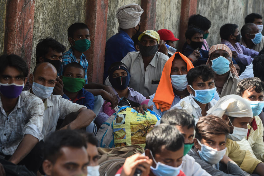 In May 2020, migrant workers wait outside the railway station in Mumbai to board trains to return to their homes. Earlier on in the pandemic they were unable to do so because of a nationwide lockdown, which was subsequently eased by the government.