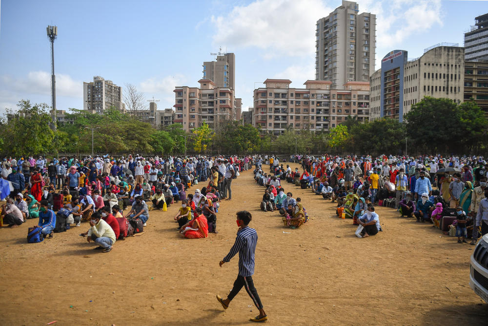 Migrant workers and their families wait inside a park on May 21, 2020, as they await transportation to a nearby railway station so they can return by train to their hometowns. The pandemic lockdown had kept them from traveling earlier, but then the government eased restrictions.