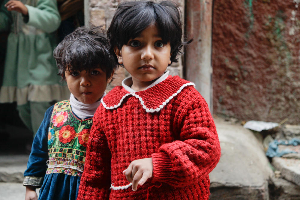 A child sticks out her pinkie finger to show she's been vaccinated. Health workers mark vaccinated children with a sharpie on the pinkie — it only fades after a week or so — to help identify children who've missed out on the oral polio vaccine dose.