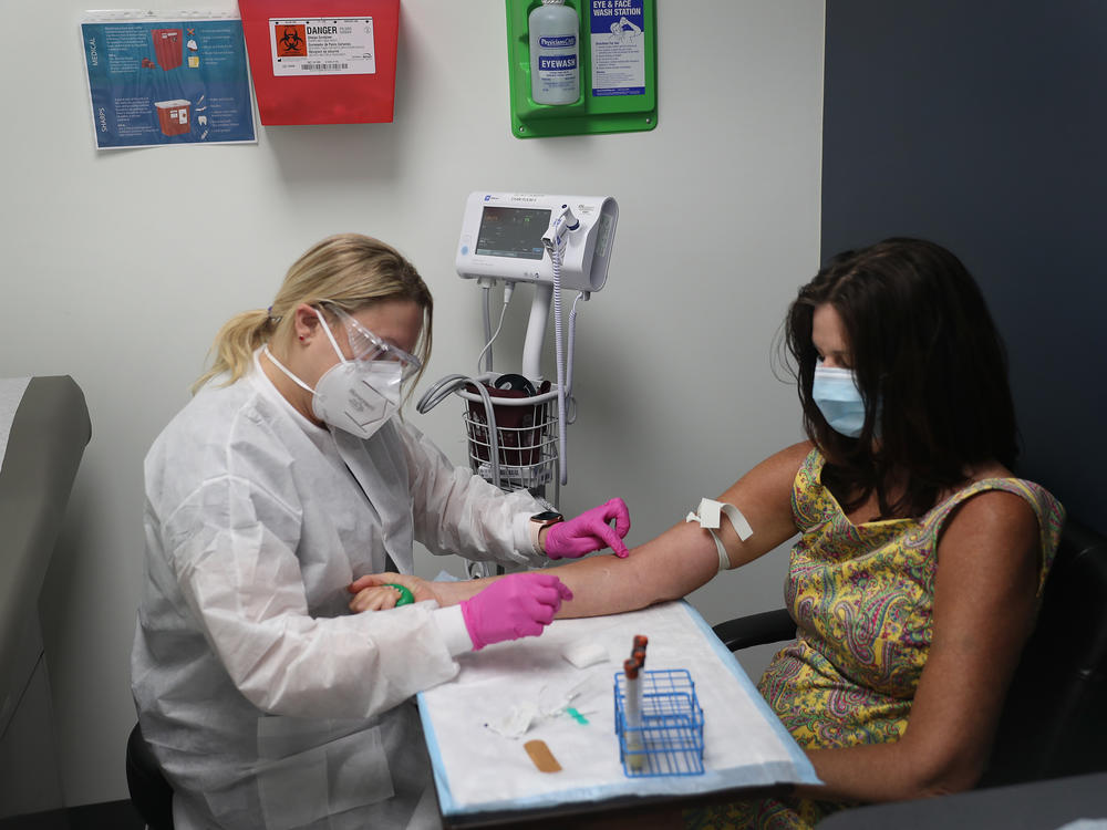 Leyda Valentine, a research coordinator, takes blood from Lisa Taylor as she participates in a COVID-19 vaccination study at Research Centers of America in Hollywood, Fla., in August 2020.