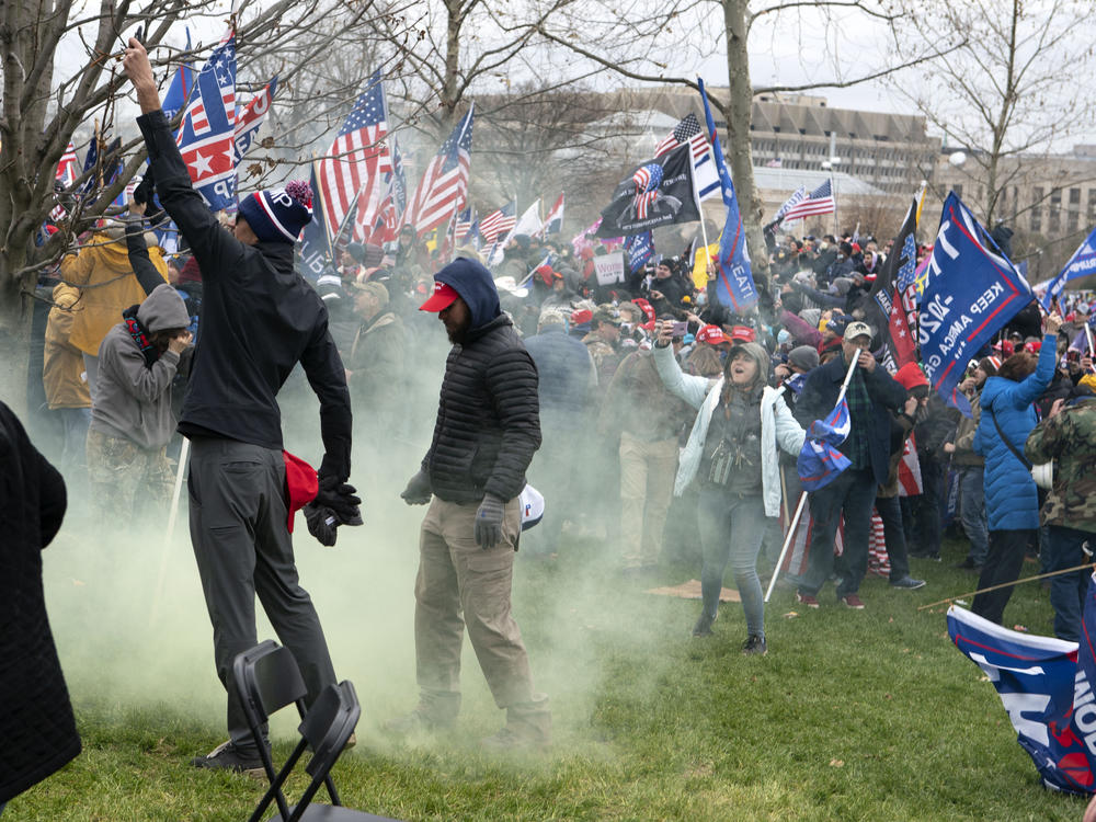 Supporters of former President Donald Trump protest as U.S. Capitol Police officers shoot tear gas during the assault on the Capitol Jan. 6.
