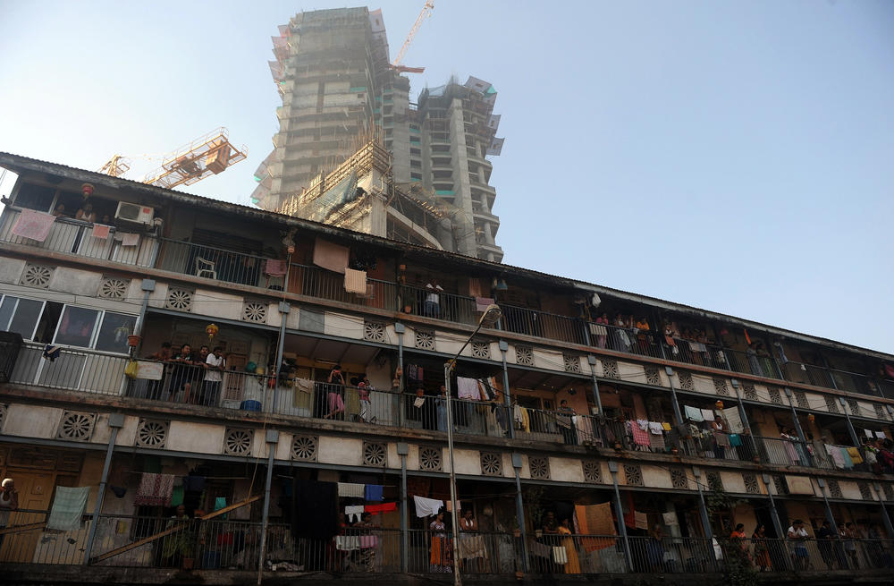 Residents of a present-day chawl stand on their common balcony. A chawl is a tenement dwelling for the working class.
