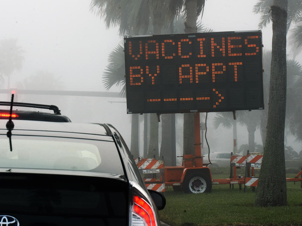 A sign directs drivers to a COVID-19 vaccination site at the Orange County Convention Center in Orlando, Fla. Health officials in Orange County said on Thursday that two women were caught dressing up as 