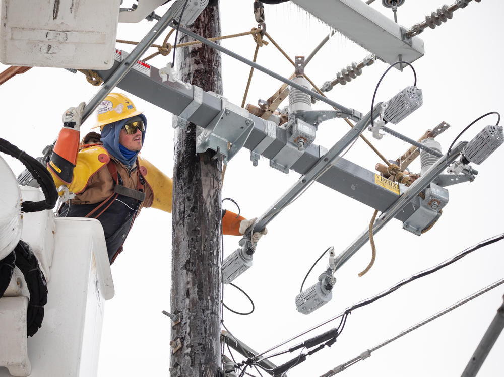 A worker repairs a power line in Austin, Texas, on Thursday. Although power was slowly being restored to much of the state, weather-related water issues persist.