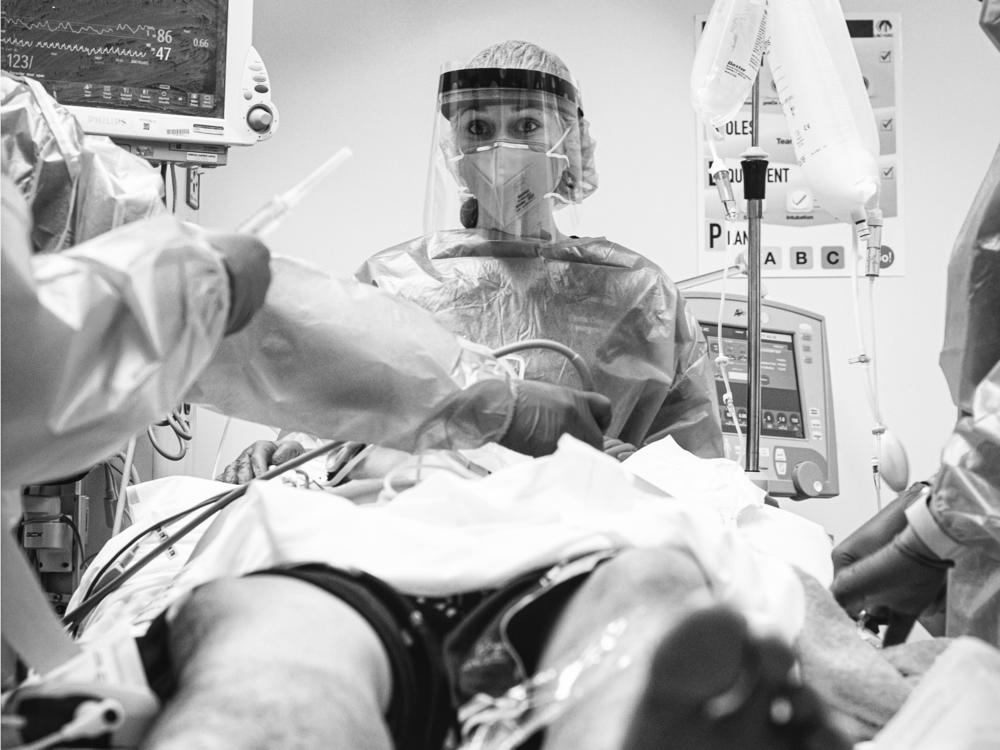 Dr. Daria Osipchuk prepares to intubate a young man in severe respiratory distress from COVID-19.