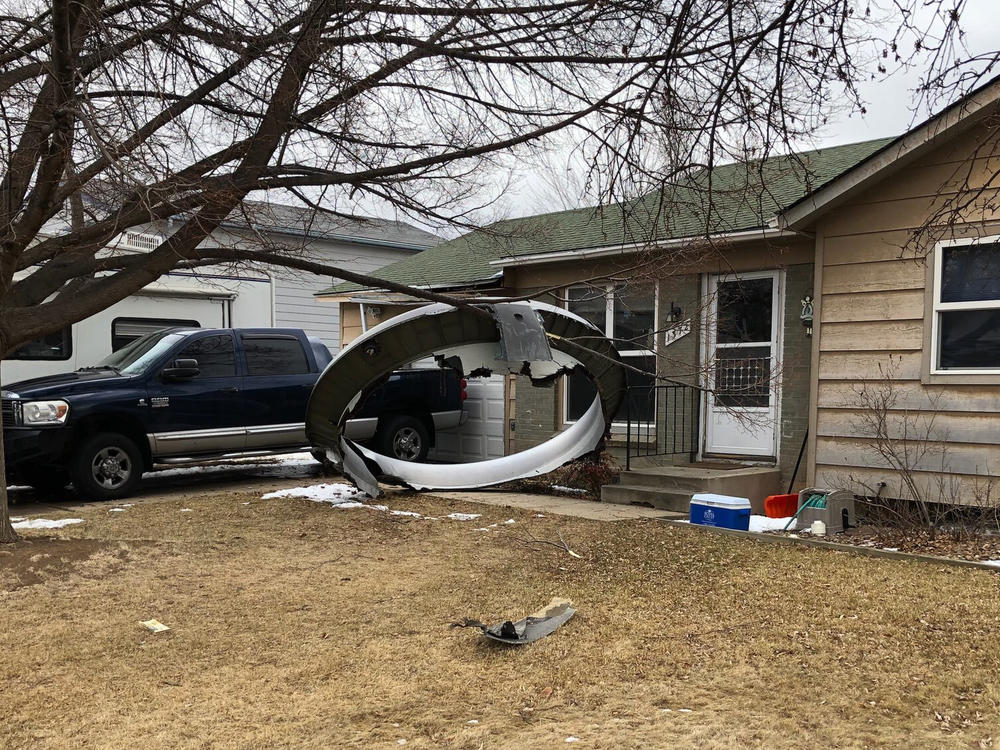 Debris is scattered in the front yard of a house in Broomfield, Colo., on Saturday. A commercial airliner dropped debris in Colorado neighborhoods during an emergency landing.