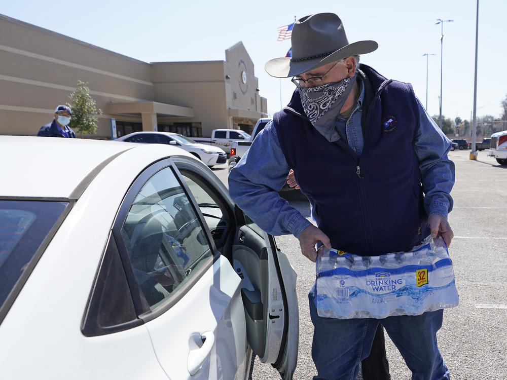 Harris County Precinct 4 Commissioner Jack Cagle hands out water at a distribution site on Friday in Houston. Millions throughout the state remain under a boil water notice as many residents lack water at home due to frozen or broken pipes.