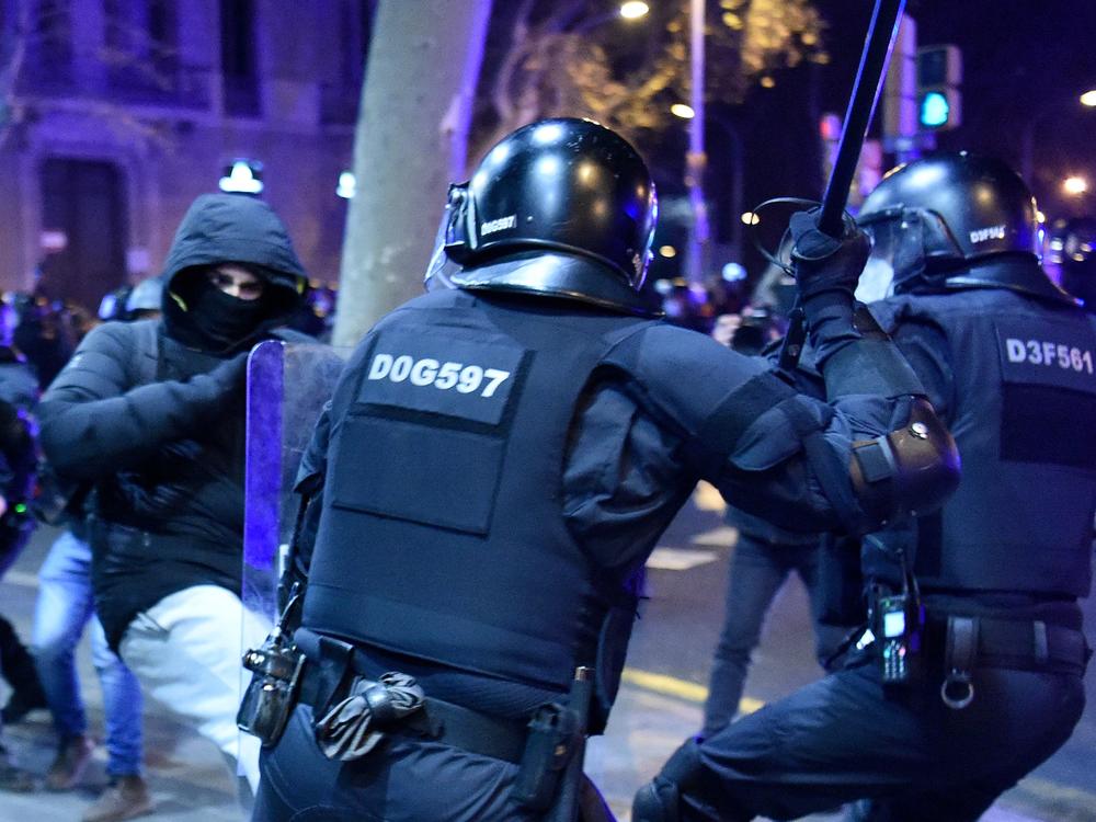 Protesters clash with Mossos d'Esquadra, the Catalan police force, following a demonstration Saturday in Barcelona against the imprisonment of Spanish rapper Pablo Hasel.