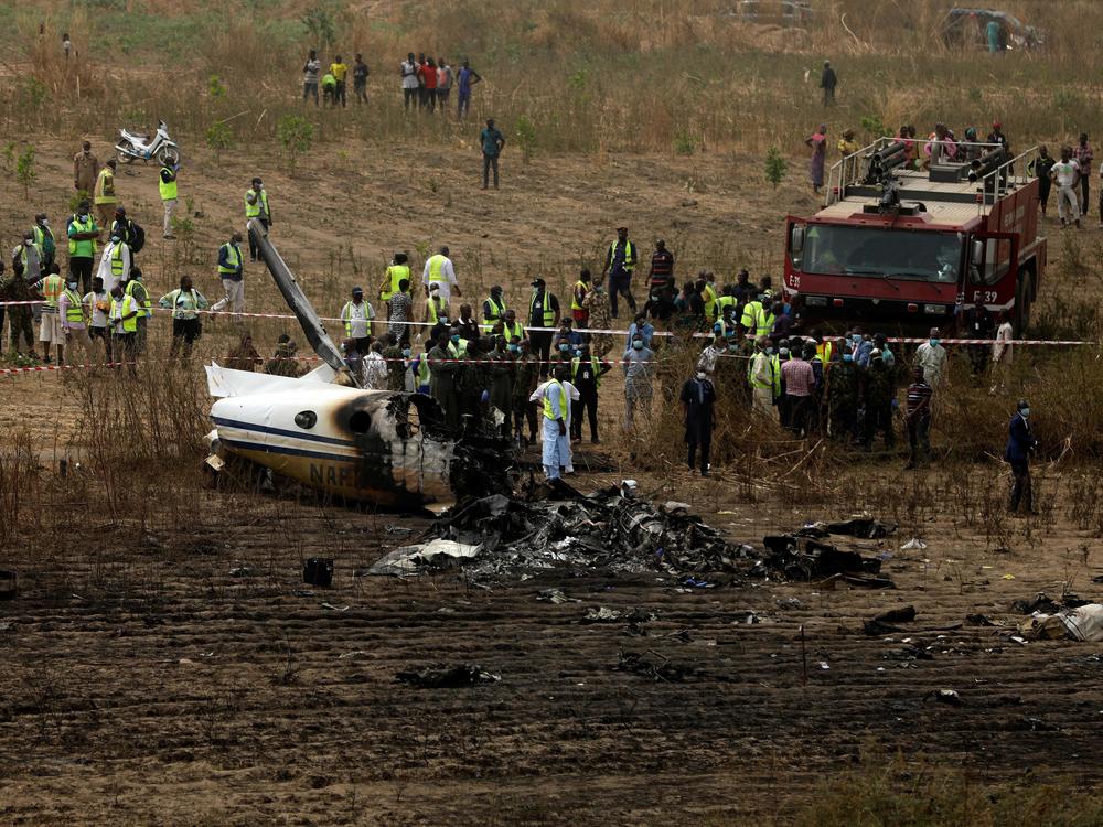 Emergency personnel work at the scene a Nigerian military aircraft crash near Abuja, Nigeria, on Sunday. All seven people on board were killed.
