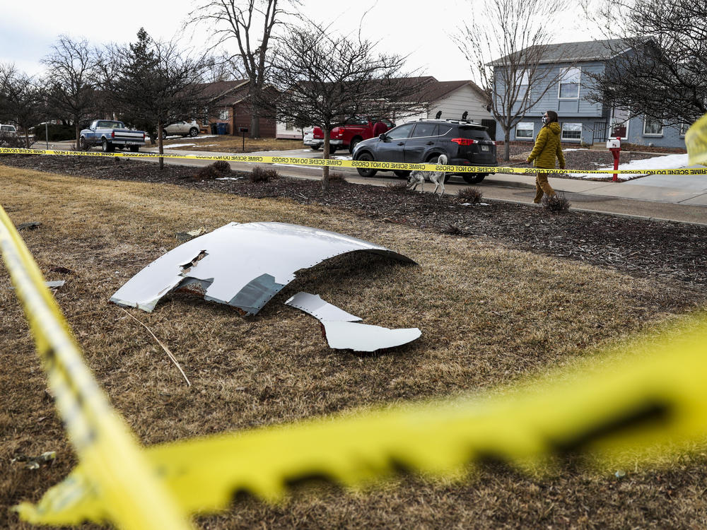 Pieces of an engine from United Airlines Flight 328 sit scattered in a neighborhood after the jet's engine failure on Saturday after takeoff from Denver.