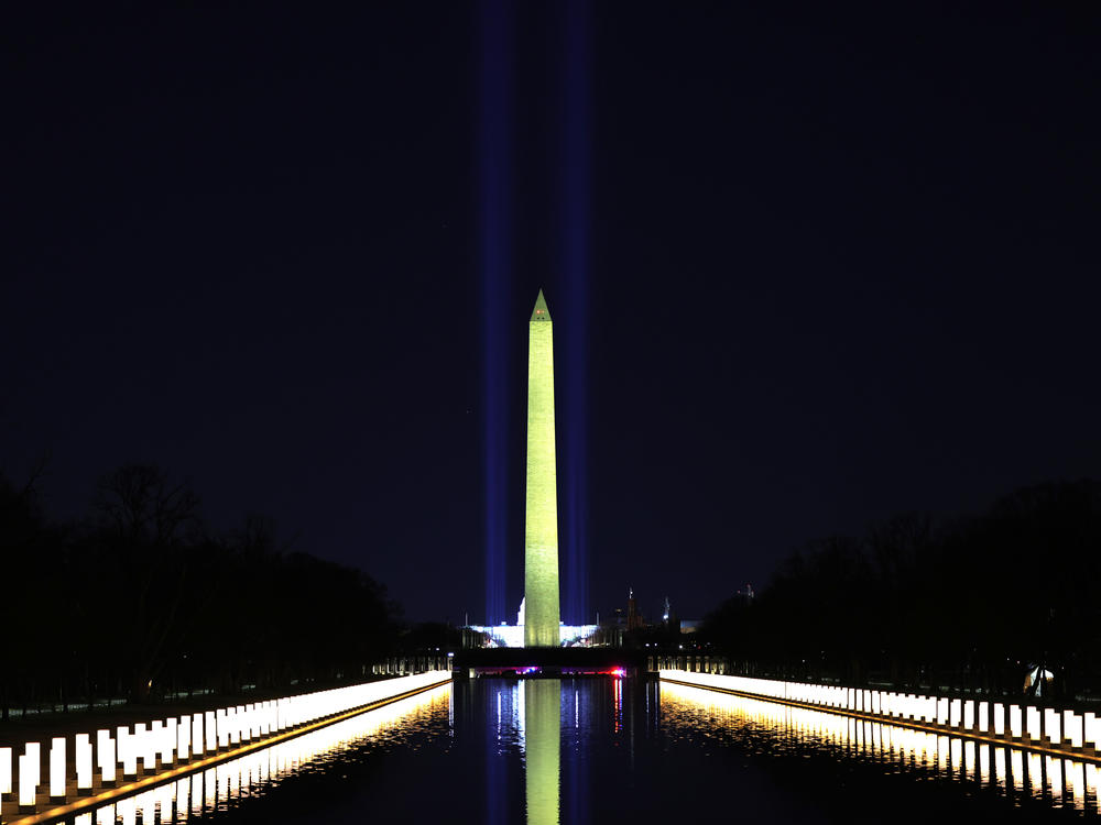 Columns along the sides of the Lincoln Memorial Reflecting Pool pay tribute to victims of COVID-19 at a Jan. 19 memorial. Just over a month later, a Monday evening ceremony will pay tribute to 500,000 Americans lives lost.