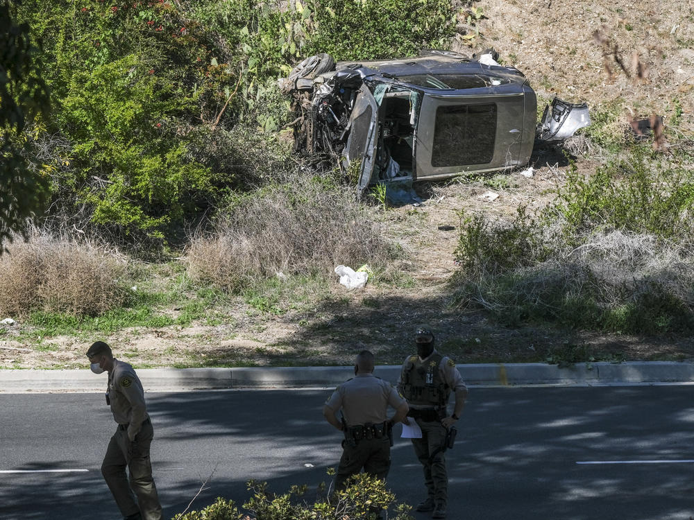 A vehicle rests on its side after a rollover accident involving golfer Tiger Woods along a road in the Rancho Palos Verdes section of Los Angeles County on Tuesday. Woods suffered leg injuries in the one-car accident and underwent surgery, authorities and his agent said.