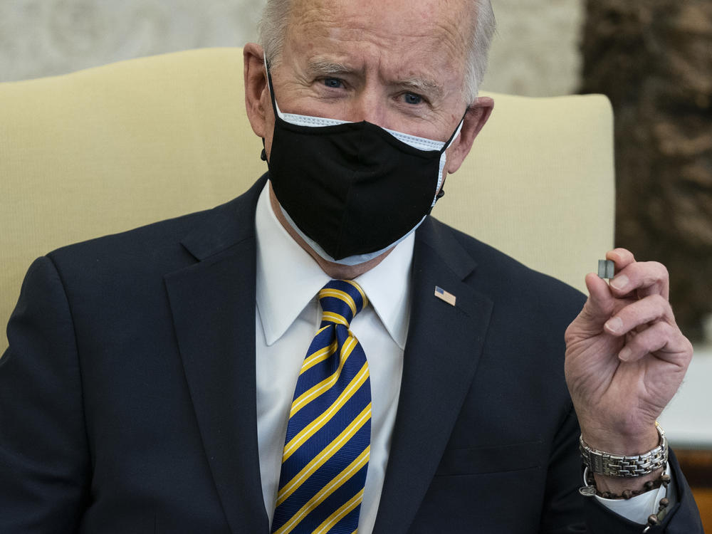 President Biden holds up a semiconductor chip during a meeting with lawmakers to discuss U.S. supply chain shortages.
