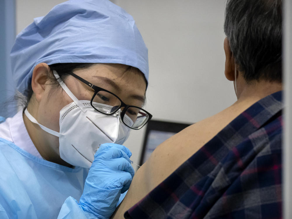 A medical worker gives a coronavirus vaccine shot to a patient at a vaccination facility in Beijing, in January. Two pharmaceutical companies in China announced Wednesday they are seeking market approval for new vaccines.