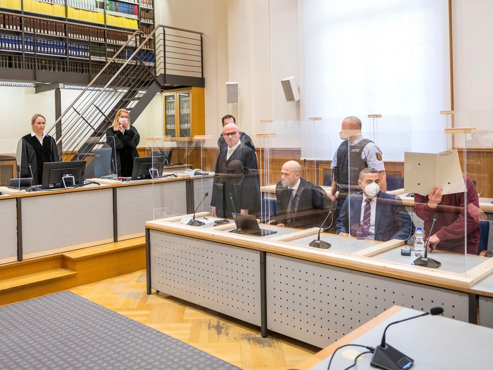 Presiding judge Anne Kerber (left) stands before handing the verdict to Syrian defendant Eyad al-Gharib (right, face hidden under a folder) Wednesday in Koblenz. Gharib, 44, a former Syrian intelligence service agent, was sentenced to 4 1/2 years in jail for complicity in crimes against humanity in the first court case over state-sponsored torture by the Syrian government.