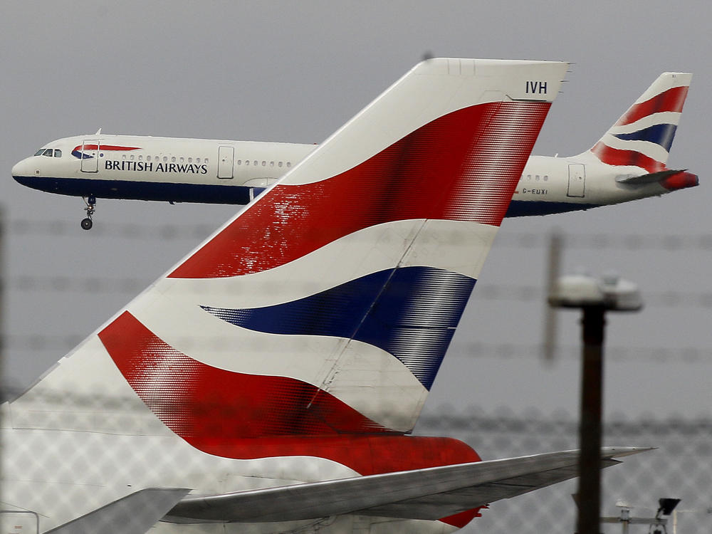 A British Airways plane comes in to land behind a tail fin at Heathrow Airport in London. On Friday, the head of the group that owns BA called for instituting an electronic health pass for passengers as the company announced steep losses due to COVID-19.