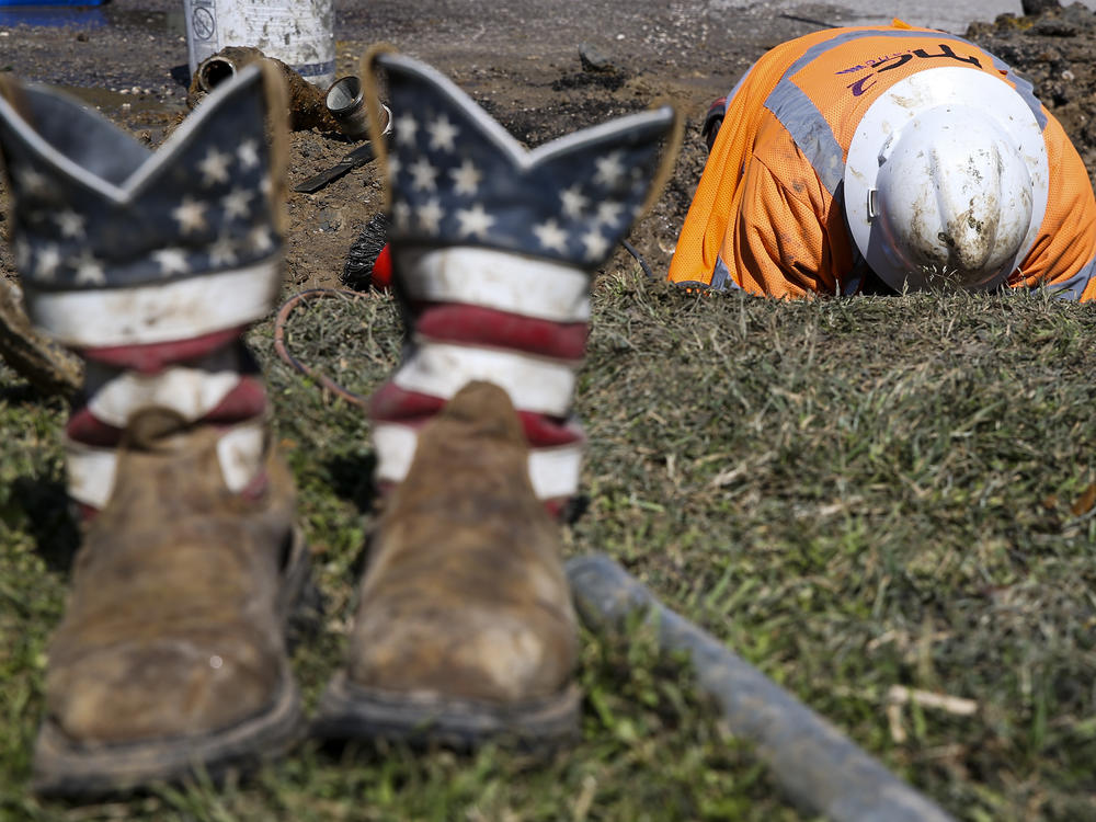 A worker fixes a water pipe in Galveston, Texas, on Feb. 19. The power is back on in much of the state, but the Lone Star State now faces the hefty cost of emerging from its devastating storms.