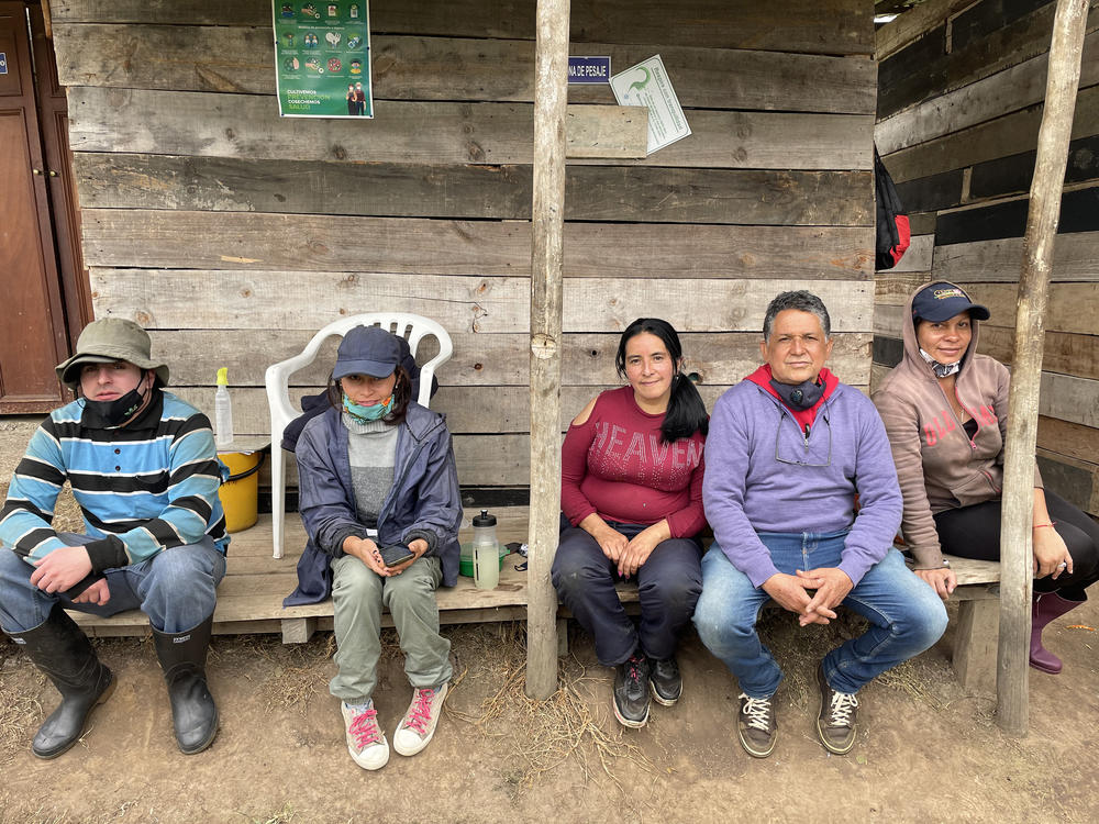 Venezuelan migrants take a lunch break at the gooseberry farm where they work on the outskirts of Bogotá, Colombia.