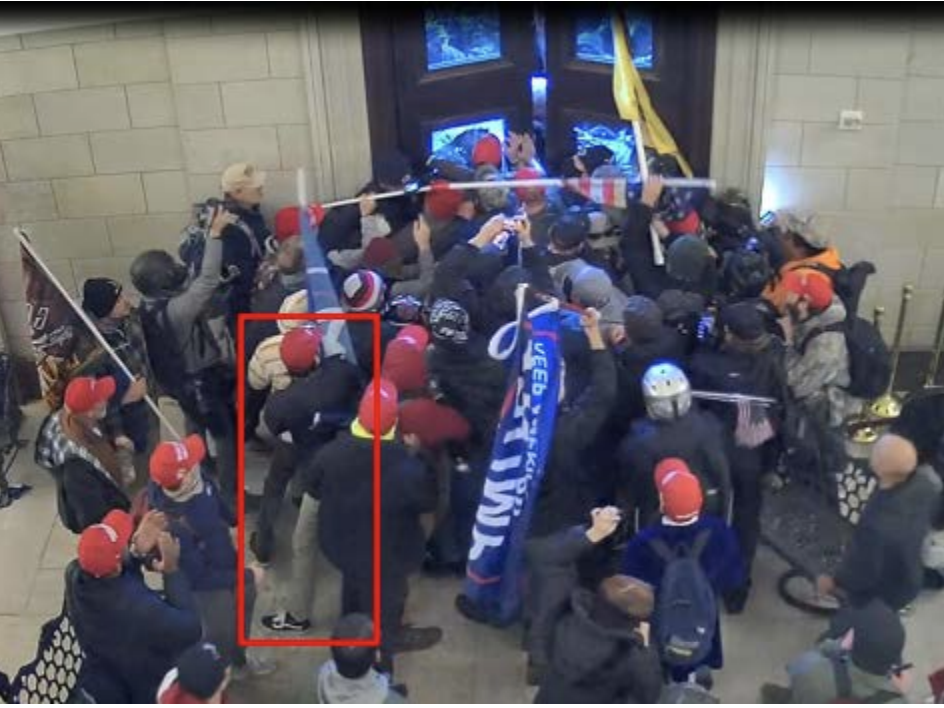 The Justice Department says Christian Secor can be seen in surveillance footage from inside the U.S. Capitol on Jan. 6. Charging papers include this screen grab, allegedly showing Secor pushing against Capitol Police officers along with other members of the mob.