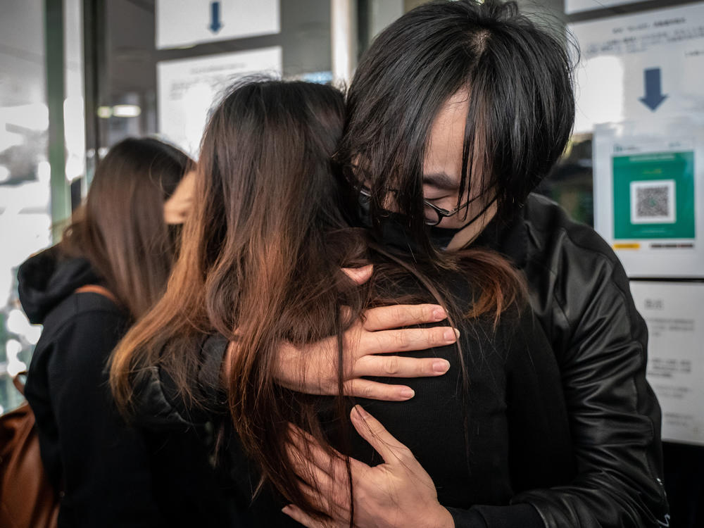 Mike Lam King-nam, who participated in the 2020 pro-democracy primary elections, gives a hug to his wife ahead of reporting to police on Sunday in Hong Kong.