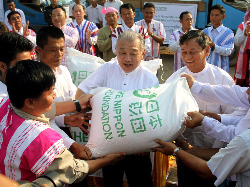 Yohei Sasakawa (center), Japan's special envoy to Myanmar and chairman of the Nippon Foundation, donates sacks of rice in Hpa-an, Karen State, Myanmar, in 2013.