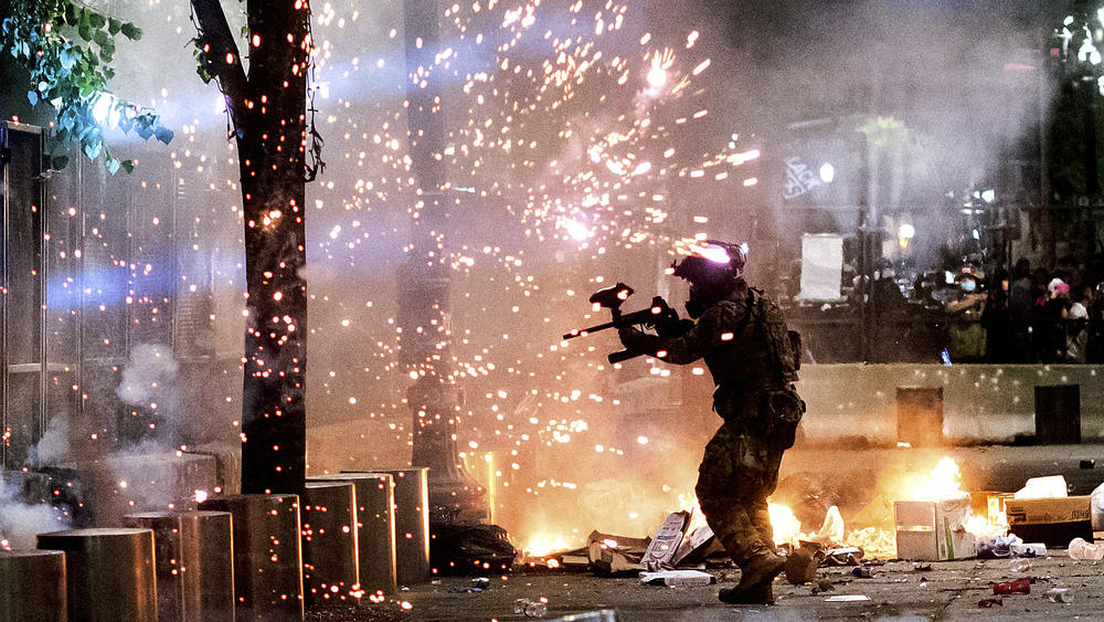 A federal officer fires crowd control munitions at protesters on July 24, 2020, in Portland, Ore. Some critics say media coverage of the protests in Portland and elsewhere last summer helped conflate Black Lives Matter protesters with individuals who associate with antifa.