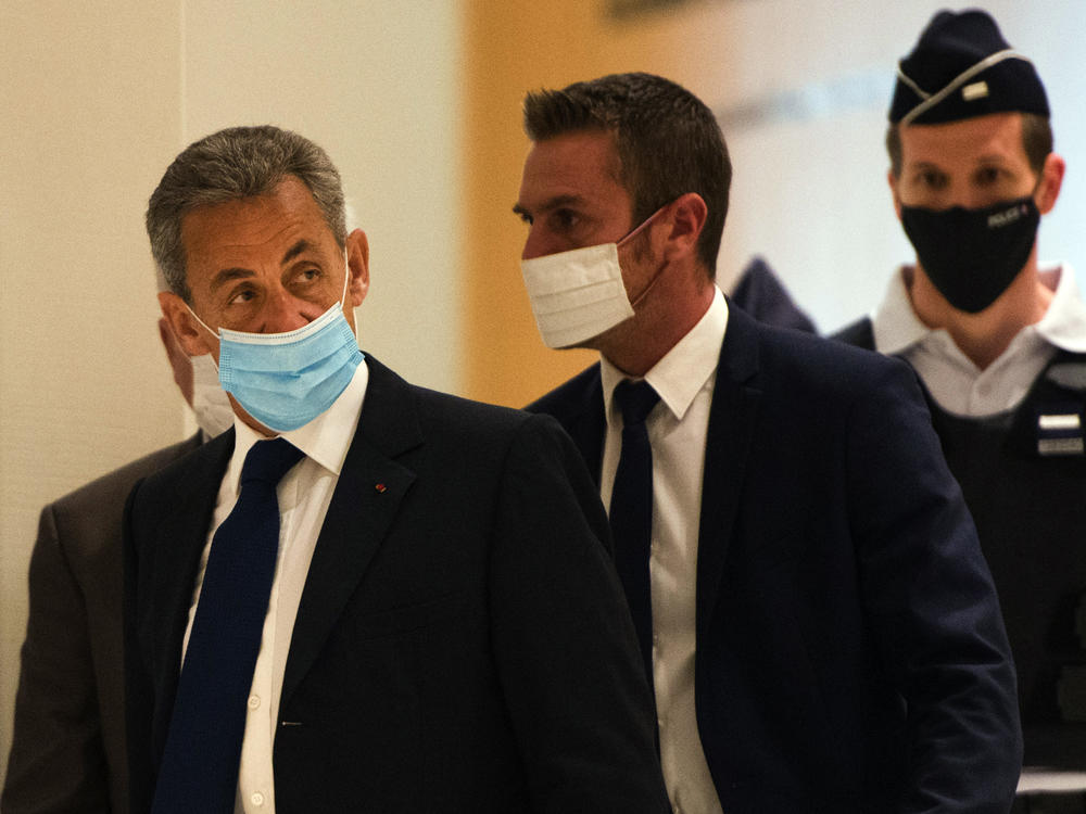 French former President Nicolas Sarkozy (left) arrives to hear the verdict in a corruption trial at Porte de Clichy court house in Paris on Monday.