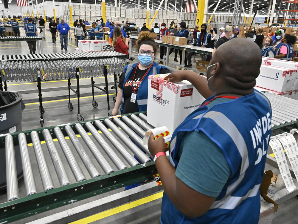 The first box of Johnson & Johnson's COVID-19 vaccine departs from a facility in Shepherdsville, Ky., on Monday. The company is set to distribute its first 3.9 million doses across the U.S. this week.