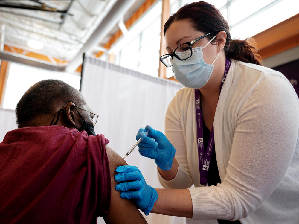 Trinity Health RN Kayla Bennett gives Hartford, Conn., resident James Watts his first dose of the COVID-19 vaccine at a neighborhood vaccine clinic at the at the Parker Memorial Community Center.