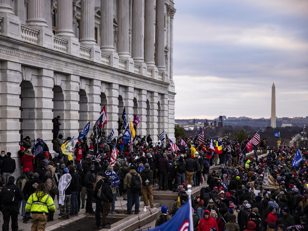 A mob of Trump supporters, many with ties to far-right groups, storms the U.S. Capitol on Jan. 6. New court documents detail the alleged role of Proud Boys member Ethan Nordean.