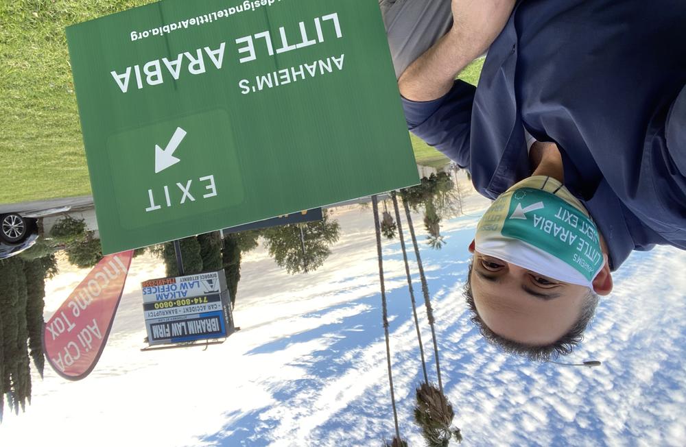 Rashad Al-Dabbagh, founder and executive director of the Arab American Civic Council, next to a lawn sign supporting the designation of Little Arabia
