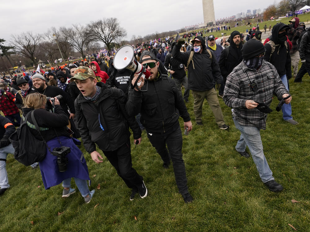 Prosecutors say Ethan Nordean, seen with a bullhorn, led members of the far-right group the Proud Boys in the Jan. 6 riot. He faces federal charges, but will be released from custody while he awaits trial.
