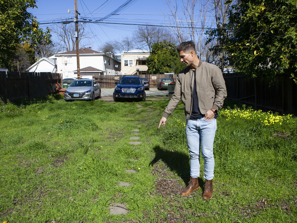 Real estate developer Kevin Khasigian points out the edges of what he hopes will one-day be a four-unit apartment building on what is now a grassy lot near Sacramento's downtown