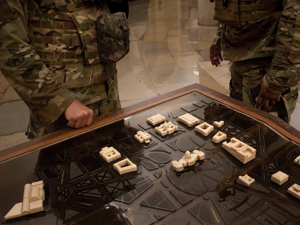National Guard members examine a terrain model of Capitol Hill on Thursday. U.S. Capitol Police requested the guardsmen stay another two months after threats of further  violence emerged.