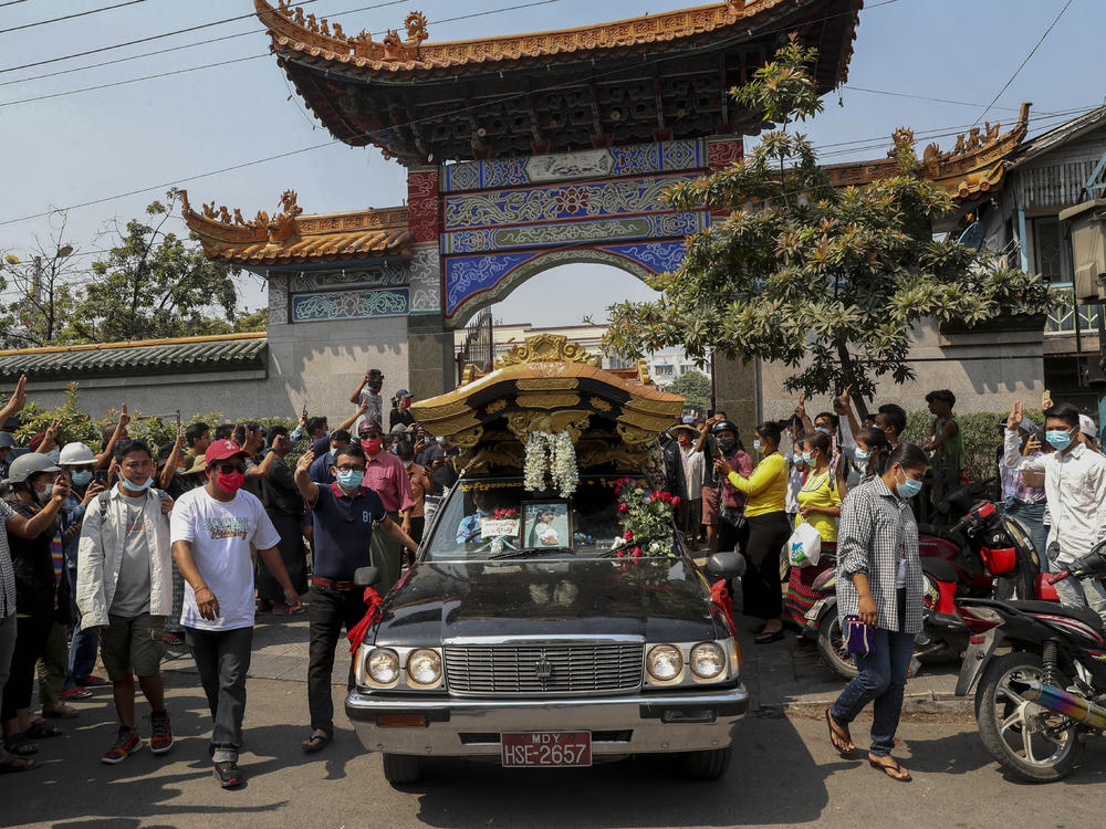Bystanders flash a three-fingered sign of resistance as the body of Kyal Sin leaves the Yunnan Chinese temple in Mandalay, Myanmar earlier this week.
