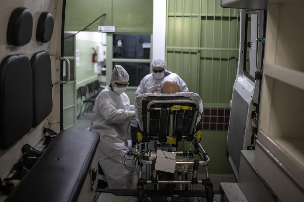 Members of the Mobile Emergency Care Service transfer a patient to a hospital in Sao Paulo state, Brazil, on Feb. 24. ICU beds are full in many hospitals, and now the COVID-19 patients include not just older Brazilians but folks in their 20s and 30s.