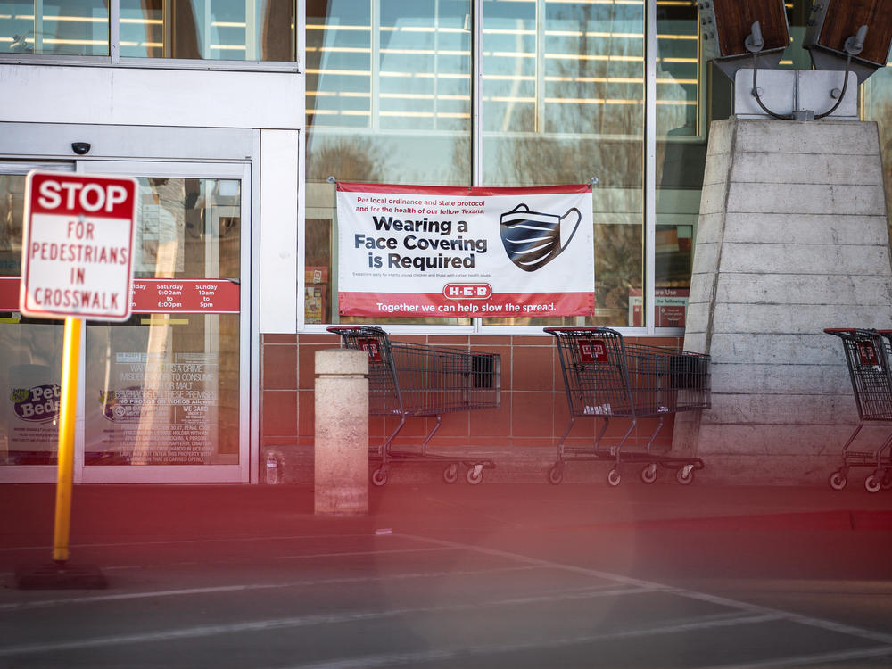 Signage requiring masks is on display outside of a H-E-B supermarket in Austin, Texas on March 3. Texas is one of the states lifting its mask mandate alongside other COVID-19 restrictions, against the warnings of public health experts.