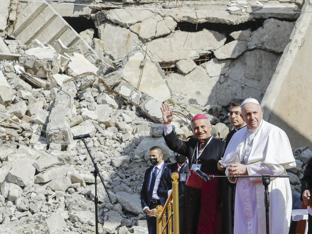 The archbishop of Mosul, Najib Mikhael Moussa (left) waves as he stands next to Pope Francis at the start of a gathering to pray for the victims of war at the Hosh al-Bieaa Church Square, in Mosul, Iraq, once the de facto capital of ISIS on Sunday.