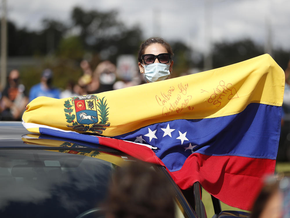 A Joe Biden supporter with a Venezuelan flag cheers during a Biden campaign event at Camping World Stadium on October 27, 2020 in Orlando, Florida.