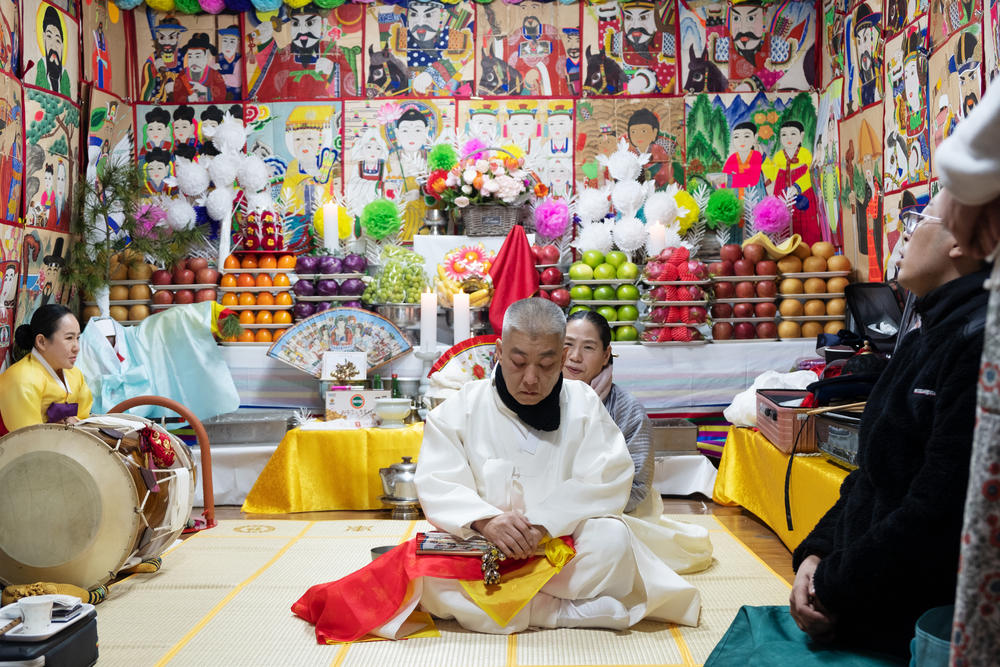 Shaman Jeong Soon-deok (rear) performs ritual purification of a new shaman during an initiation ceremony at a temple in Seoul.