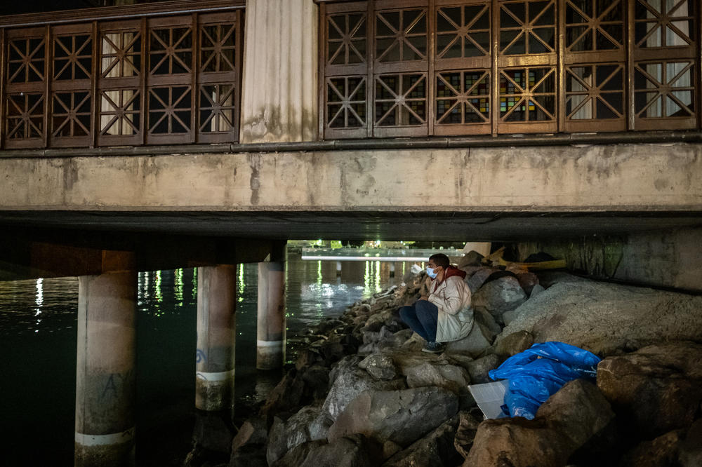 A migrant prepares to sleep under a platform next to the dock in the port of Las Palmas on the island of Gran Canaria.