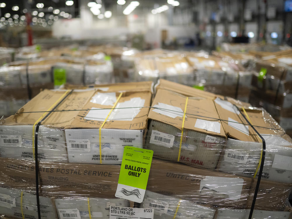 Pallets filled with Washington and Oregon mail-in ballots fill an unloading area at a U.S. Postal Service processing and distribution center on Oct. 14, 2020, in Portland, Ore.